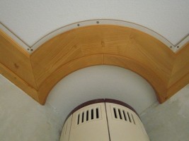 Decke in Fichte massiv, gebeizt, mit übernommener Rundung des Ofens